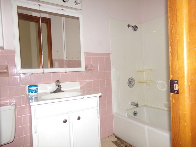 full bathroom featuring toilet, bathtub / shower combination, vanity, and tile walls