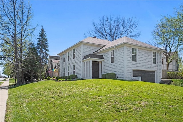 view of front of property featuring a garage and a front lawn