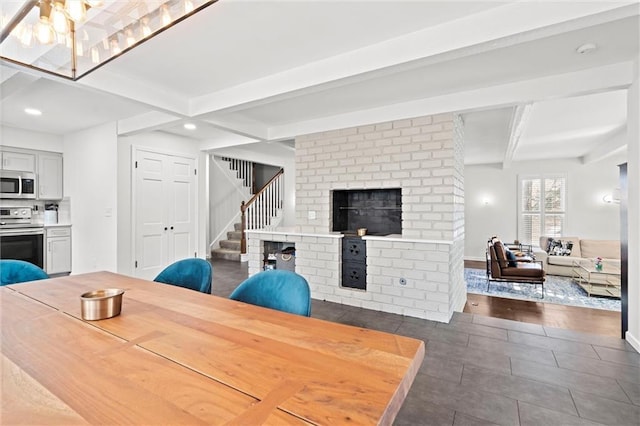 dining space featuring beam ceiling and a fireplace