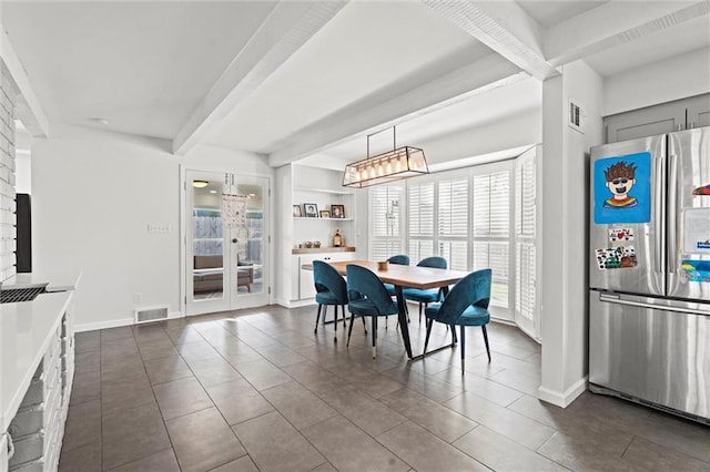 tiled dining space with built in features and beamed ceiling