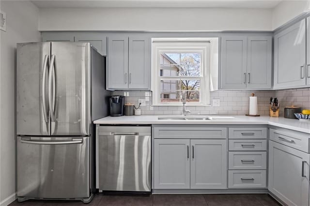 kitchen with stainless steel appliances, gray cabinetry, and sink