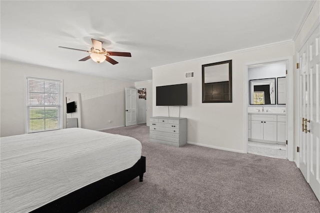 carpeted bedroom with ensuite bath, ceiling fan, sink, and crown molding