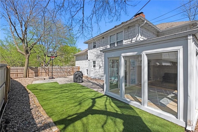 rear view of property featuring a lawn and a patio