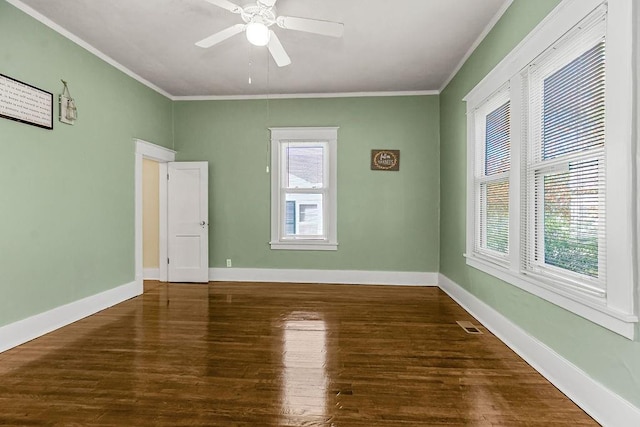 spare room featuring dark wood-type flooring, ceiling fan, and crown molding