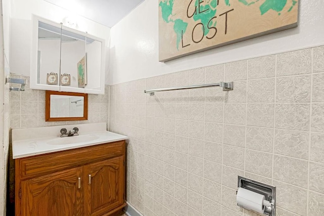 bathroom featuring vanity and tile walls