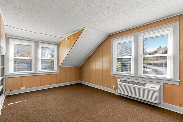 bonus room with a wall mounted air conditioner, lofted ceiling, wooden walls, and carpet