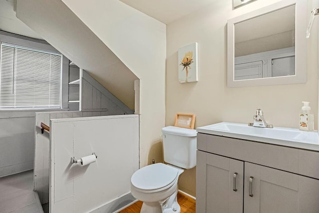 bathroom with vanity, toilet, and hardwood / wood-style floors