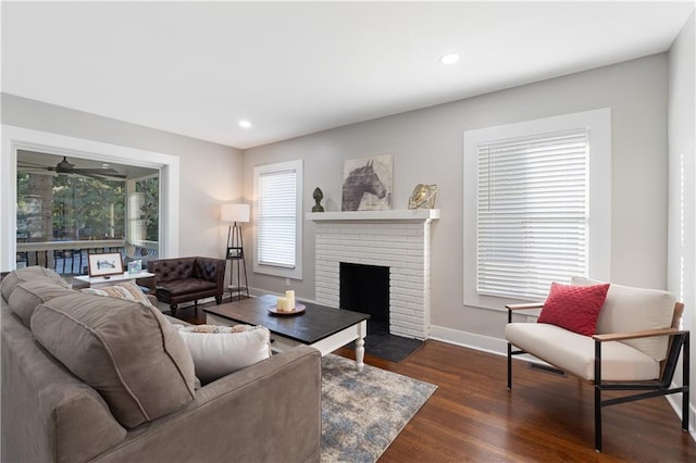 living room with dark hardwood / wood-style flooring, a fireplace, and a wealth of natural light