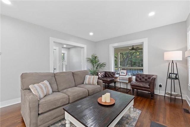 living room with ceiling fan and dark hardwood / wood-style flooring