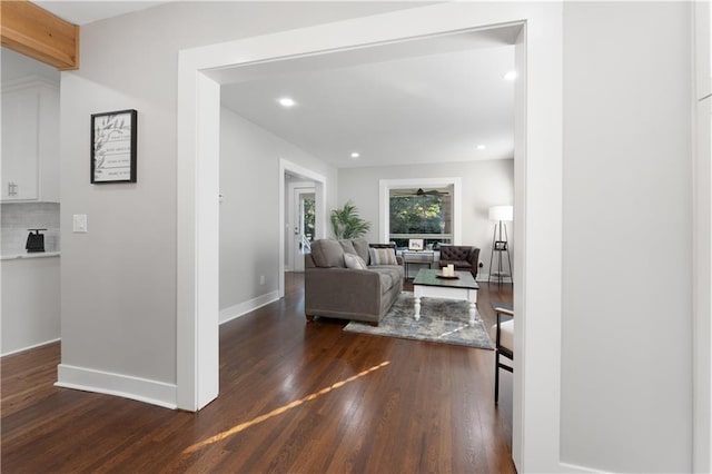 living room featuring ceiling fan and dark hardwood / wood-style flooring