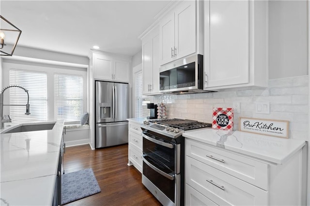 kitchen featuring sink, white cabinets, appliances with stainless steel finishes, light stone counters, and dark hardwood / wood-style flooring