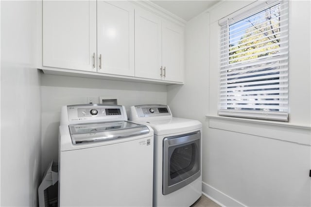 washroom with cabinets and washing machine and clothes dryer