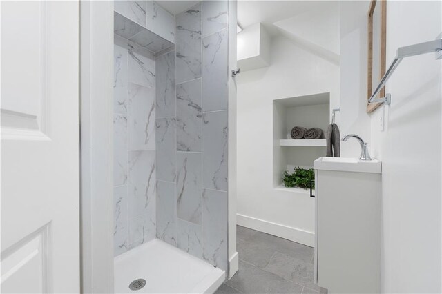 bathroom with vanity and tiled shower