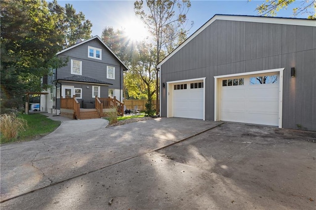 view of side of property featuring a deck, an outbuilding, and a garage