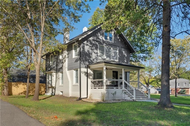 view of front facade featuring covered porch and a front lawn