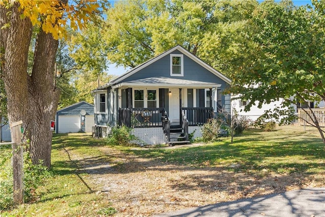 bungalow-style home with a porch, a front yard, an outbuilding, and a garage