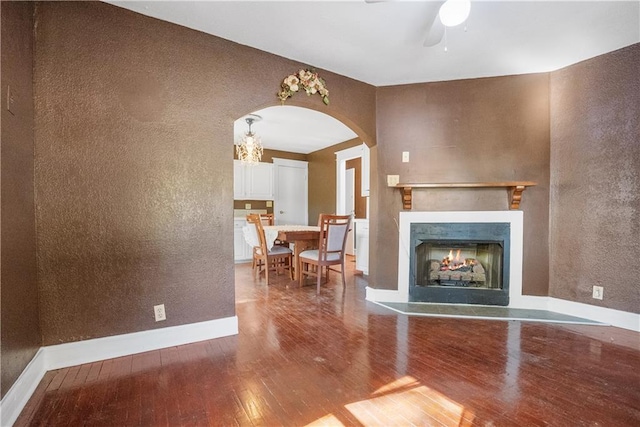 unfurnished living room featuring wood-type flooring and ceiling fan