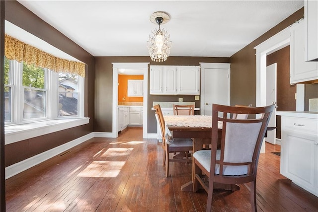 dining area featuring hardwood / wood-style flooring and a chandelier