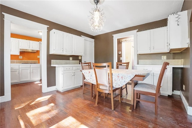 dining area with a notable chandelier and dark hardwood / wood-style floors