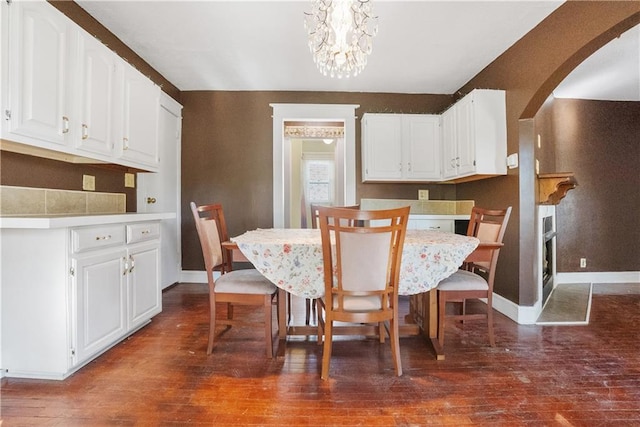 dining room with dark hardwood / wood-style flooring and a chandelier