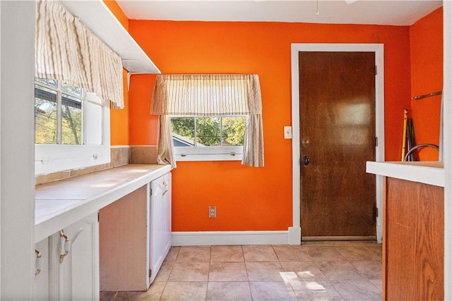 clothes washing area featuring a wealth of natural light and light tile patterned floors