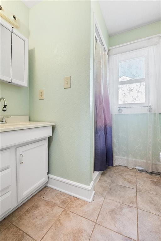 bathroom featuring vanity, curtained shower, and tile patterned floors