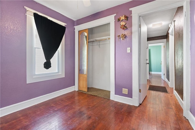 unfurnished bedroom with a closet, ceiling fan, and hardwood / wood-style flooring