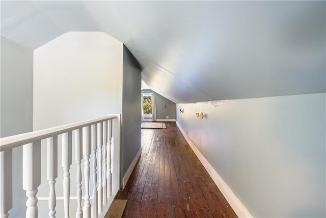 hallway featuring vaulted ceiling and dark hardwood / wood-style flooring