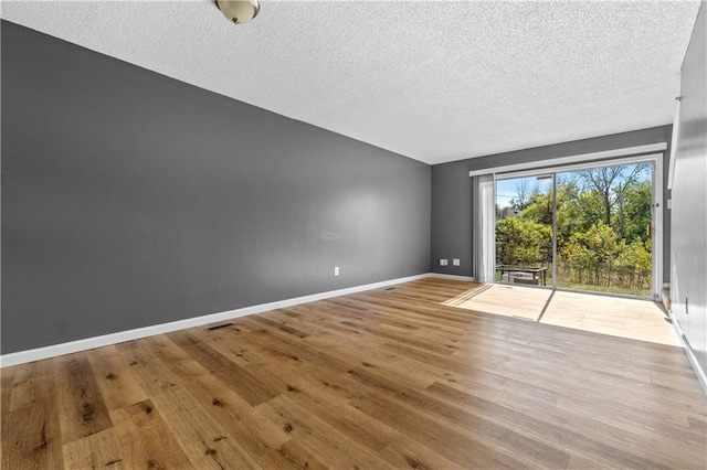 spare room with wood-type flooring and a textured ceiling