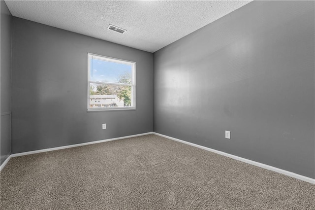 empty room featuring carpet and a textured ceiling