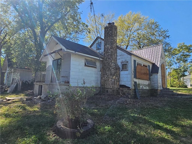 view of property exterior with a yard and a chimney