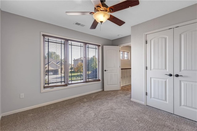 unfurnished bedroom with light colored carpet, a closet, and ceiling fan