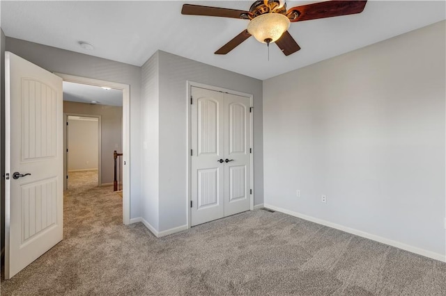 unfurnished bedroom with light colored carpet, a closet, and ceiling fan