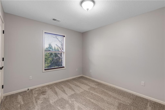 carpeted spare room with a textured ceiling