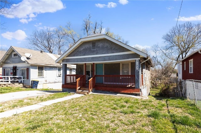 bungalow-style home featuring covered porch and a front lawn