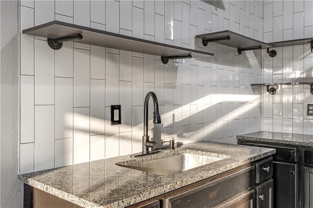 kitchen with tasteful backsplash, sink, and dark stone counters