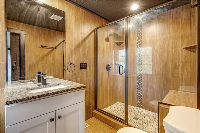 bathroom with a shower with door, wood-type flooring, toilet, wooden ceiling, and vanity