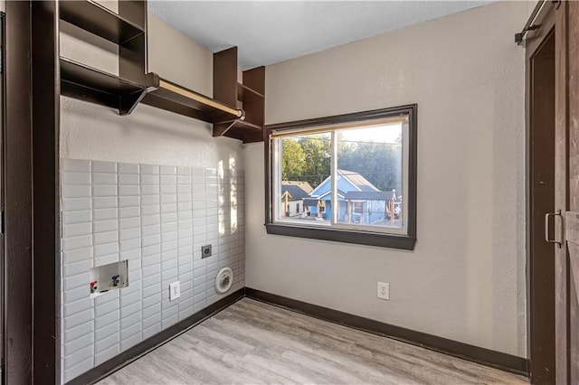 washroom featuring light hardwood / wood-style flooring, washer hookup, and hookup for an electric dryer