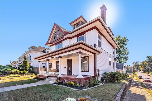 view of front of house featuring covered porch and a front lawn