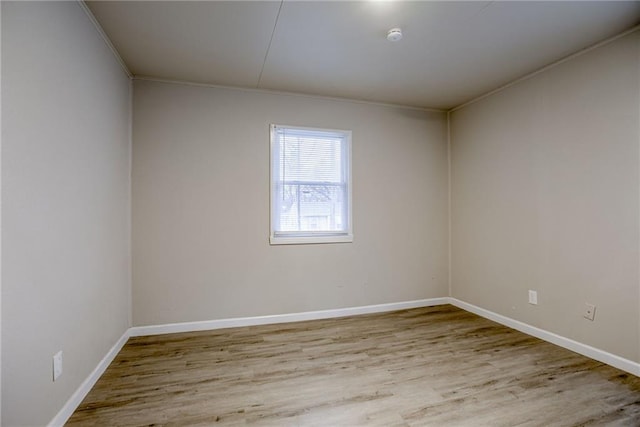 unfurnished room with ornamental molding and light wood-type flooring