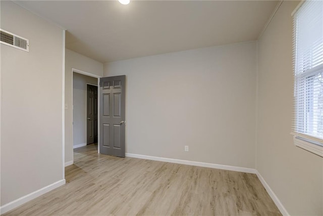 empty room featuring ornamental molding and light hardwood / wood-style flooring