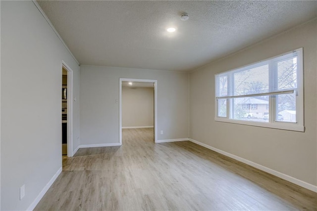 empty room featuring light hardwood / wood-style floors and a textured ceiling