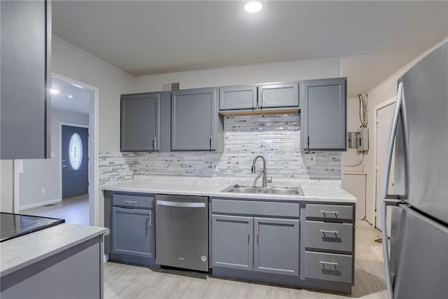 kitchen with stainless steel appliances, sink, and gray cabinets