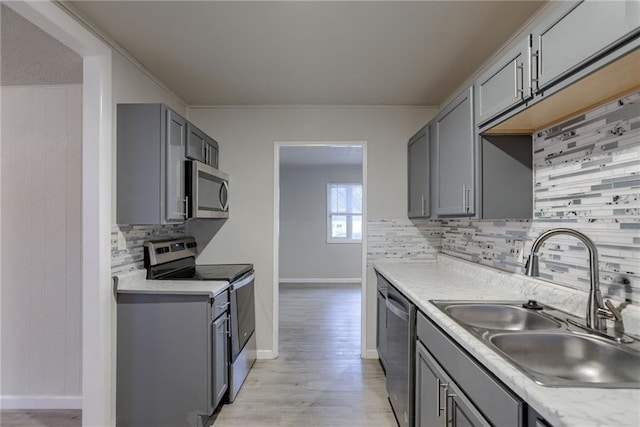 kitchen with stainless steel appliances, sink, and gray cabinetry