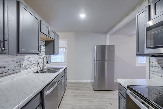 kitchen featuring light hardwood / wood-style floors, appliances with stainless steel finishes, gray cabinets, and sink