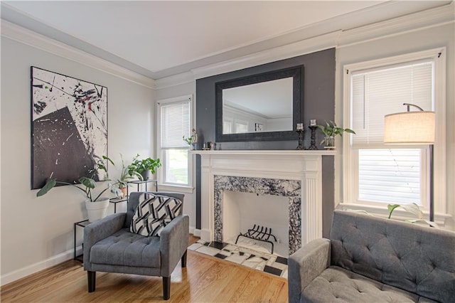 living area with ornamental molding, hardwood / wood-style flooring, a fireplace, and plenty of natural light