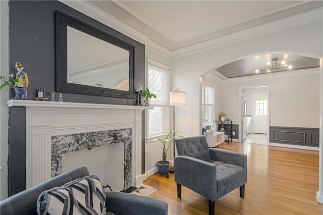 living room featuring a fireplace, crown molding, and hardwood / wood-style floors