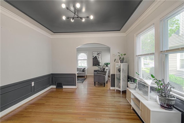 corridor featuring ornamental molding, a chandelier, and light hardwood / wood-style floors