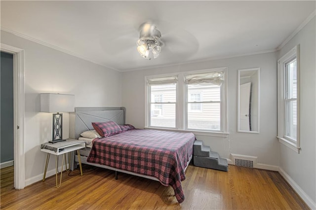 bedroom featuring ceiling fan, crown molding, and hardwood / wood-style floors