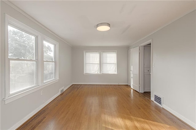 unfurnished room featuring hardwood / wood-style flooring and crown molding